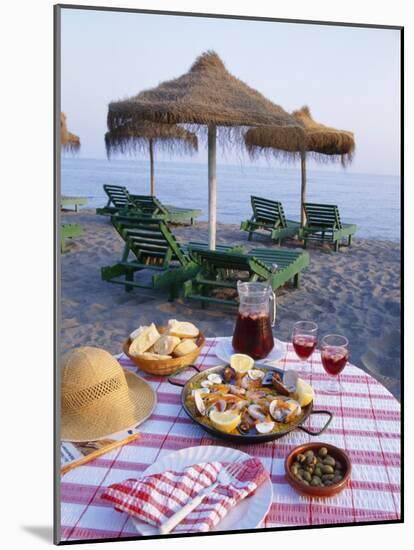 Paella with Olives, Bread and Sangria on a Table on the Beach in Andalucia, Spain-Michael Busselle-Mounted Photographic Print