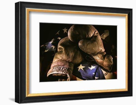 Pair of vintage boxing gloves laying on a flag carefully painted with light-Sheila Haddad-Framed Photographic Print