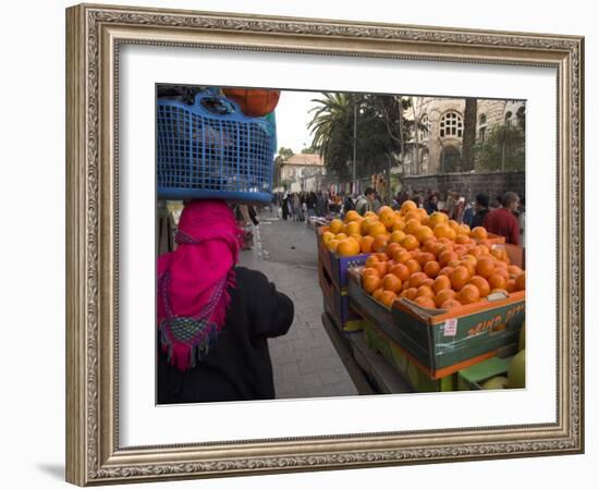 Palestinian Woman in Colourful Scarf and Carrying Bag on Her Head Walking Past an Orange Stall-Eitan Simanor-Framed Photographic Print