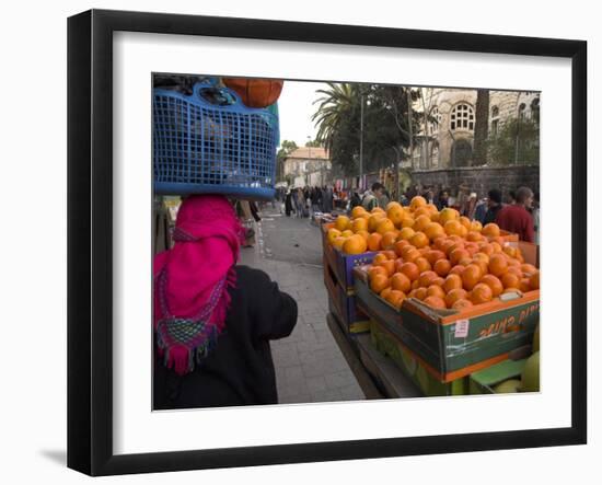 Palestinian Woman in Colourful Scarf and Carrying Bag on Her Head Walking Past an Orange Stall-Eitan Simanor-Framed Photographic Print