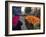 Palestinian Woman in Colourful Scarf and Carrying Bag on Her Head Walking Past an Orange Stall-Eitan Simanor-Framed Photographic Print