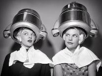 1950s TWO WOMEN SITTING UNDER BEAUTY SALON HAIR DRYERS WEARING HAIRNETS TOWELS TALKING GOSSIP-Panoramic Images-Photographic Print