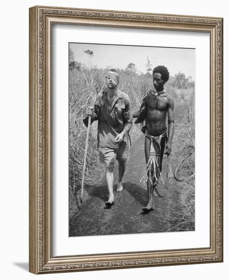 Papuan Native Helping a Wounded Australian Infantryman Along Road Away from the Buna Battlefront-George Silk-Framed Photographic Print