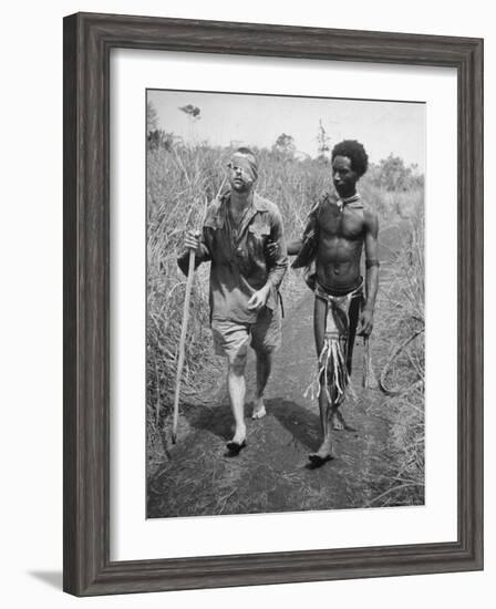 Papuan Native Helping a Wounded Australian Infantryman Along Road Away from the Buna Battlefront-George Silk-Framed Photographic Print