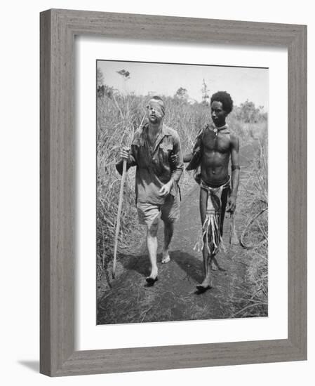 Papuan Native Helping a Wounded Australian Infantryman Along Road Away from the Buna Battlefront-George Silk-Framed Photographic Print