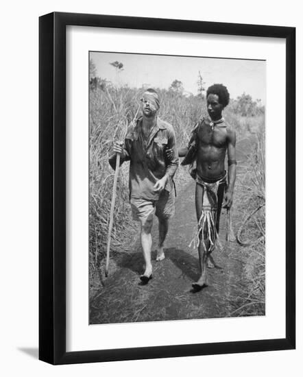 Papuan Native Helping a Wounded Australian Infantryman Along Road Away from the Buna Battlefront-George Silk-Framed Photographic Print