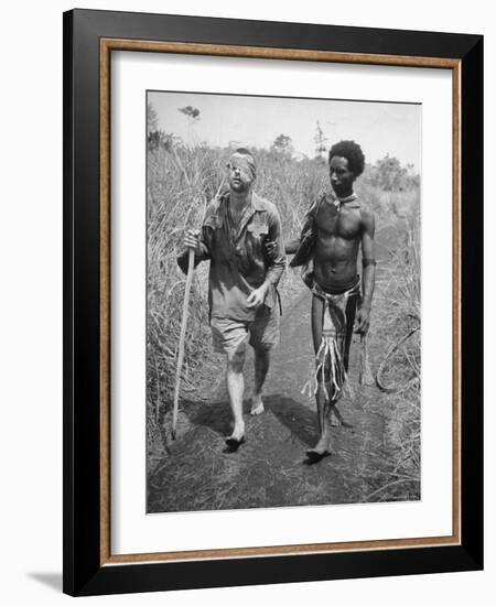 Papuan Native Helping a Wounded Australian Infantryman Along Road Away from the Buna Battlefront-George Silk-Framed Photographic Print