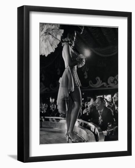 Patron at Stage-Side Table Looks Appraisingly at Tall Show Girl Standing at Edge of Stage-Gjon Mili-Framed Photographic Print