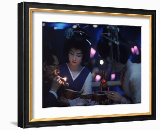 Patron of Nightclub Uruwashi Having His Cigarette Lit by Geisha-Eliot Elisofon-Framed Photographic Print