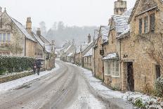 Snow covered houses by By Brook in Castle Combe with a dog enjoying a paddle, Wiltshire, England, U-Paul Porter-Photographic Print