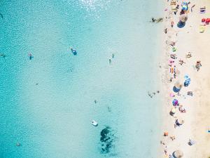 Aerial View of Sandy Beach with Tourists Swimming in Beautiful Clear Sea Water by paul prescott