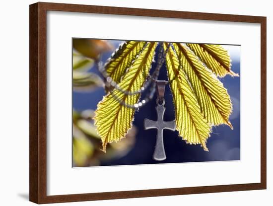 Pendant with cross on a young green chestnut leaf at springtime-null-Framed Giclee Print