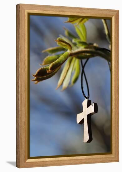 Pendant with cross on a young green chestnut leaf at springtime-null-Framed Premier Image Canvas