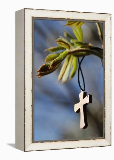 Pendant with cross on a young green chestnut leaf at springtime-null-Framed Premier Image Canvas