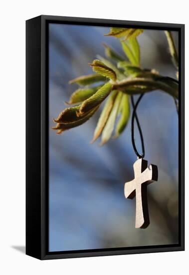 Pendant with cross on a young green chestnut leaf at springtime-null-Framed Premier Image Canvas