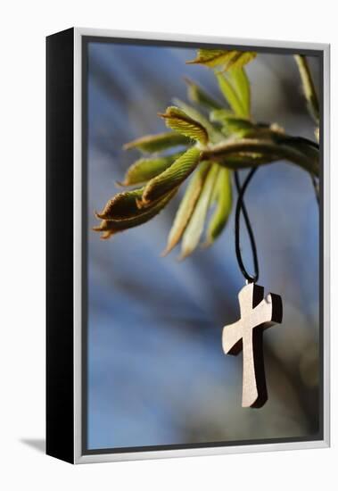 Pendant with cross on a young green chestnut leaf at springtime-null-Framed Premier Image Canvas