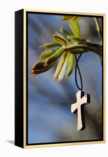 Pendant with cross on a young green chestnut leaf at springtime-null-Framed Premier Image Canvas