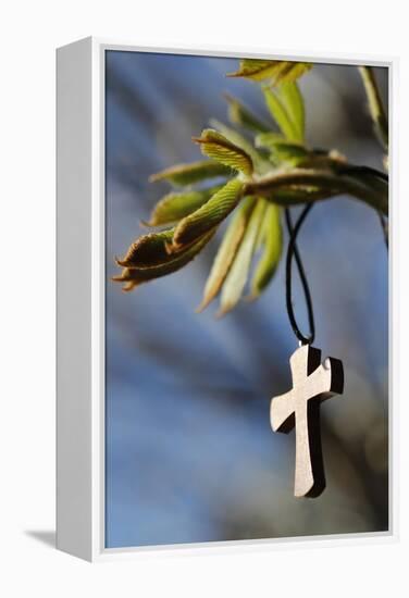 Pendant with cross on a young green chestnut leaf at springtime-null-Framed Premier Image Canvas