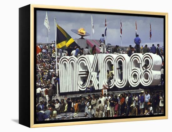 People Climbing and Sitting on a Mexico '68 Sign at the Summer Olympics-John Dominis-Framed Premier Image Canvas