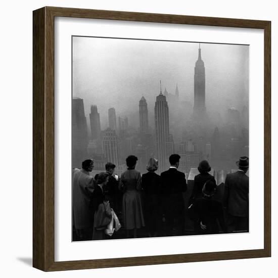 People on Top of a Building Looking Down Into Downtown Misty Smog covering Empire state Building-Eliot Elisofon-Framed Photographic Print