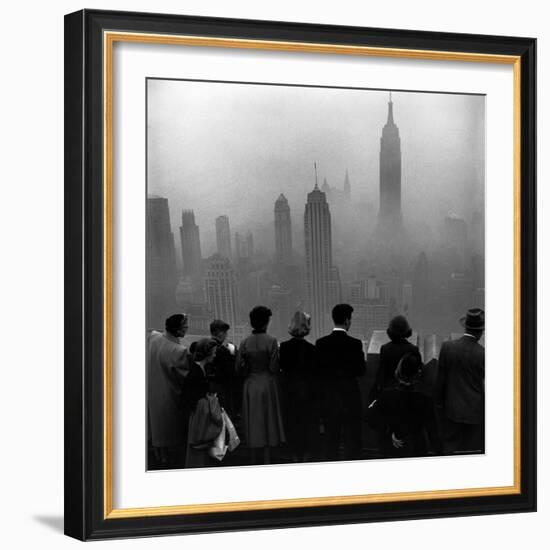 People on Top of a Building Looking Down Into Downtown Misty Smog covering Empire state Building-Eliot Elisofon-Framed Photographic Print