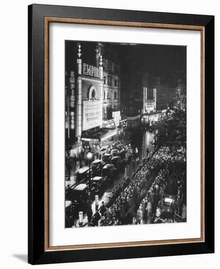 People Waiting in Front of the Brightly Lighted Empire Theatre for the Royal Film Performance-Cornell Capa-Framed Photographic Print