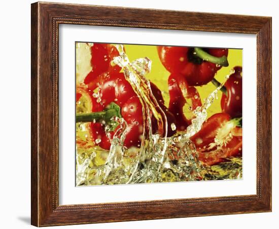 Peppers Falling into Water Against Yellow Background-Michael Meisen-Framed Photographic Print