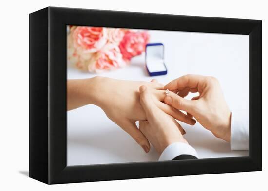 Picture of Man Putting Wedding Ring on Woman Hand-dolgachov-Framed Premier Image Canvas