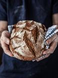 Baker Man Holding Rustic Organic Loaf of Bread in Hands - Rural Bakery. Natural Light, Moody Backgr-Pinkyone-Photographic Print