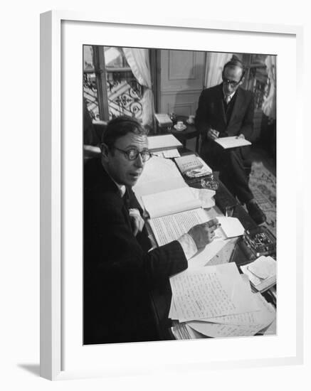 Playwright Jean Paul Sartre at His Desk as Artist Saul Steinberg Sketches at Sartre's Home in Paris-Gjon Mili-Framed Premium Photographic Print