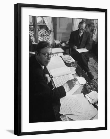 Playwright Jean Paul Sartre at His Desk as Artist Saul Steinberg Sketches at Sartre's Home in Paris-Gjon Mili-Framed Premium Photographic Print