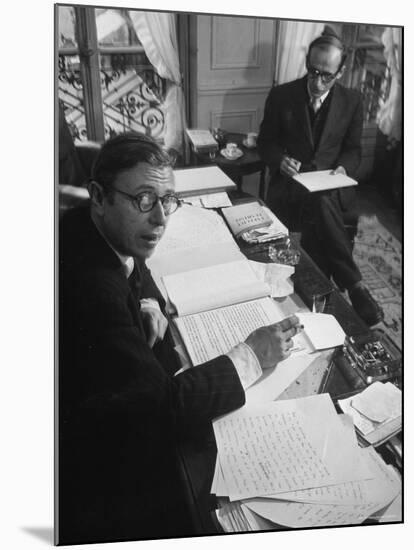 Playwright Jean Paul Sartre at His Desk as Artist Saul Steinberg Sketches at Sartre's Home in Paris-Gjon Mili-Mounted Premium Photographic Print