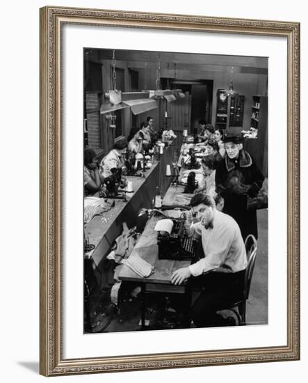 Playwright Paddy Chayefsky Sitting at Typewriter in Garment Factory With Workers on Sewing Machines-Michael Rougier-Framed Premium Photographic Print