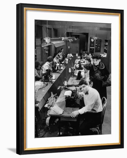 Playwright Paddy Chayefsky Sitting at Typewriter in Garment Factory With Workers on Sewing Machines-Michael Rougier-Framed Premium Photographic Print