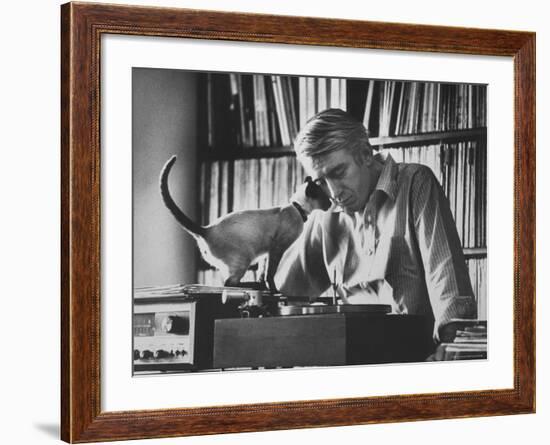 Poet Rod McKuen Playing Record on Stereo Set While Pet Siamese Cat Nuzzles His Face Affectionately-Ralph Crane-Framed Premium Photographic Print