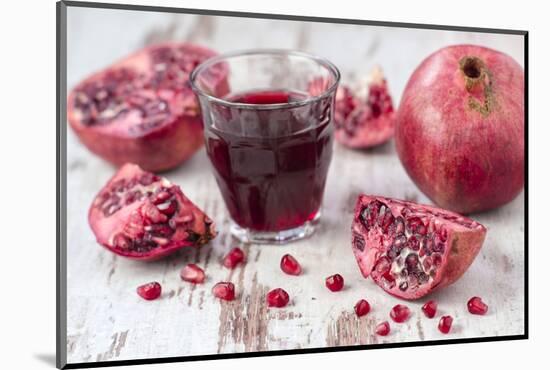 Pomegranates and Glass with Pomegranate Juice on White Wooden Table-Jana Ihle-Mounted Photographic Print