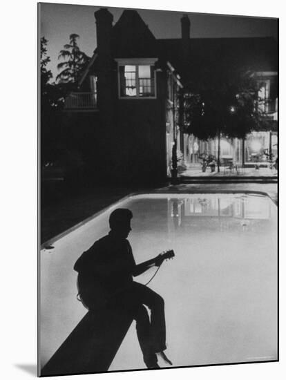 Pop Singer Ricky Nelson Sitting on Diving Board of Family Swimming Pool-Hank Walker-Mounted Premium Photographic Print