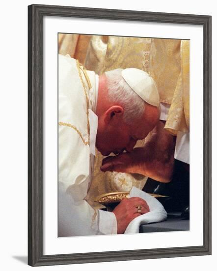 Pope John Paul II Kisses the Foot of a Clergyman-null-Framed Photographic Print