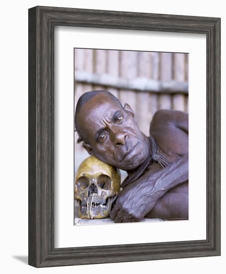 Portrait of an Asmat Tribesman Leaning on a Human Skull, Irian Jaya, Indonesia-Claire Leimbach-Framed Photographic Print