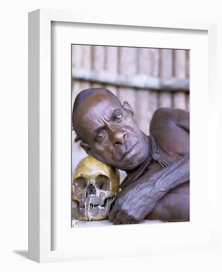 Portrait of an Asmat Tribesman Leaning on a Human Skull, Irian Jaya, Indonesia-Claire Leimbach-Framed Photographic Print