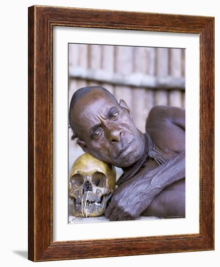 Portrait of an Asmat Tribesman Leaning on a Human Skull, Irian Jaya, Indonesia-Claire Leimbach-Framed Photographic Print