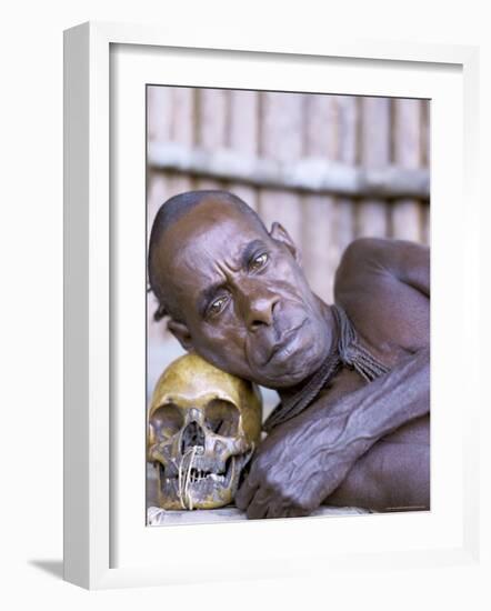 Portrait of an Asmat Tribesman Leaning on a Human Skull, Irian Jaya, Indonesia-Claire Leimbach-Framed Photographic Print