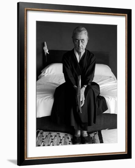 Portrait of Artist Georgia O'Keeffe Holding a Book by Leonard Baskinin Her Bedroom-John Loengard-Framed Premium Photographic Print