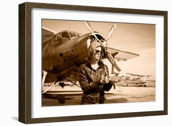 Portrait of Beautiful Female Pilot with Plane Behind. Sepia Photo.-Aleksandar Todorovic-Framed Art Print