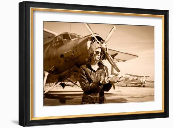 Portrait of Beautiful Female Pilot with Plane Behind. Sepia Photo.-Aleksandar Todorovic-Framed Art Print