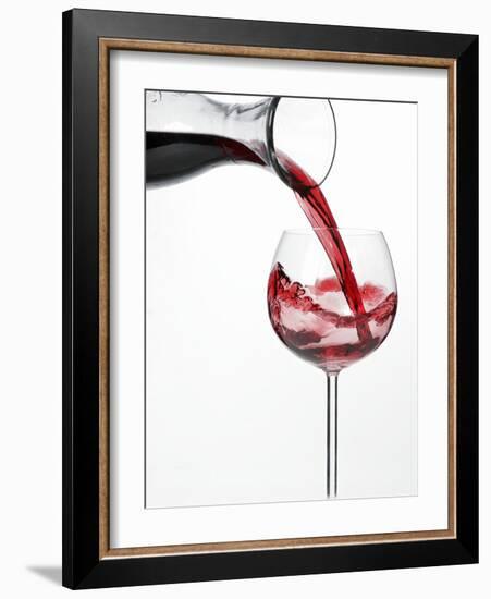 Pouring Red Wine into Glass from Carafe-Kröger & Gross-Framed Photographic Print