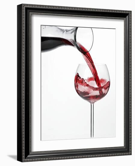 Pouring Red Wine into Glass from Carafe-Kröger & Gross-Framed Photographic Print