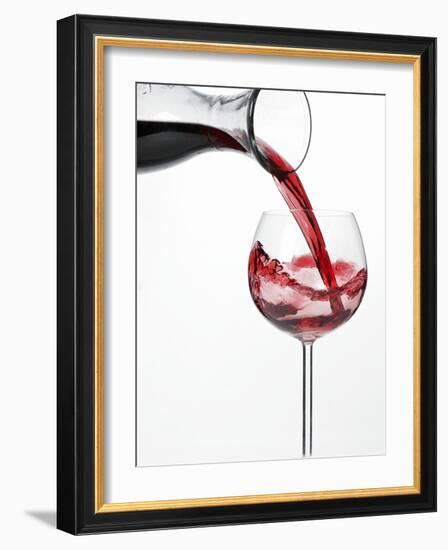 Pouring Red Wine into Glass from Carafe-Kröger & Gross-Framed Photographic Print