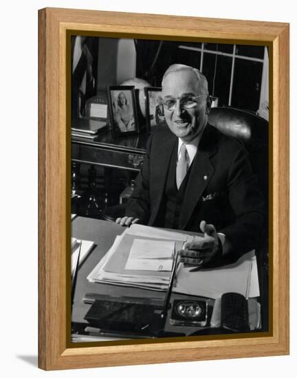 Pres. Harry S. Truman Seated at His Desk in the White House, Family Photographs on Table Behind Him-Gjon Mili-Framed Premier Image Canvas