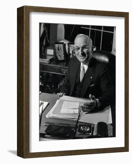 Pres. Harry S. Truman Seated at His Desk in the White House, Family Photographs on Table Behind Him-Gjon Mili-Framed Photographic Print